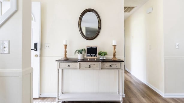 A hallway with a white console table, a mirror, and a welcome sign. - Centally located w/ coffee bar, theatre/gameroom (Orangeburg)
