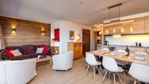 Una sala de estar moderna con un sofá, sillones y una mesa de comedor preparada para seis personas.