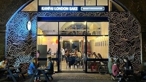 A restaurant with a distinctive wave-patterned facade and a sign reading 'KANPAI LONDON SAKE.' - The City Song 1 bedroom apartment in Rotherhithe (London)