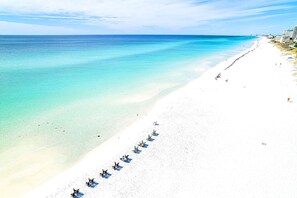 Ranta lähistöllä, aurinkotuoleja, rantapyyhkeitä