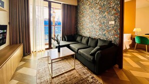 Uma sala de estar moderna com um sofá seccional, uma mesa de centro e uma parede estampada.