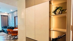 Uma sala de estar moderna com um sofá, cadeiras, uma mesa de centro e um guarda-roupa embutido com prateleiras.