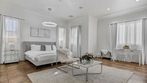A spacious bedroom with a large bed, a desk, and a chair. - Natural Springs-2 acre, Games+karaoke, fit,views. (Riverside County)