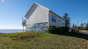 A house with a mural of a sailboat on the side, located near a body of water. - 10M From the Ocean! Upper Suite with Amazing Views - Highest Tides in the World (Five Houses)