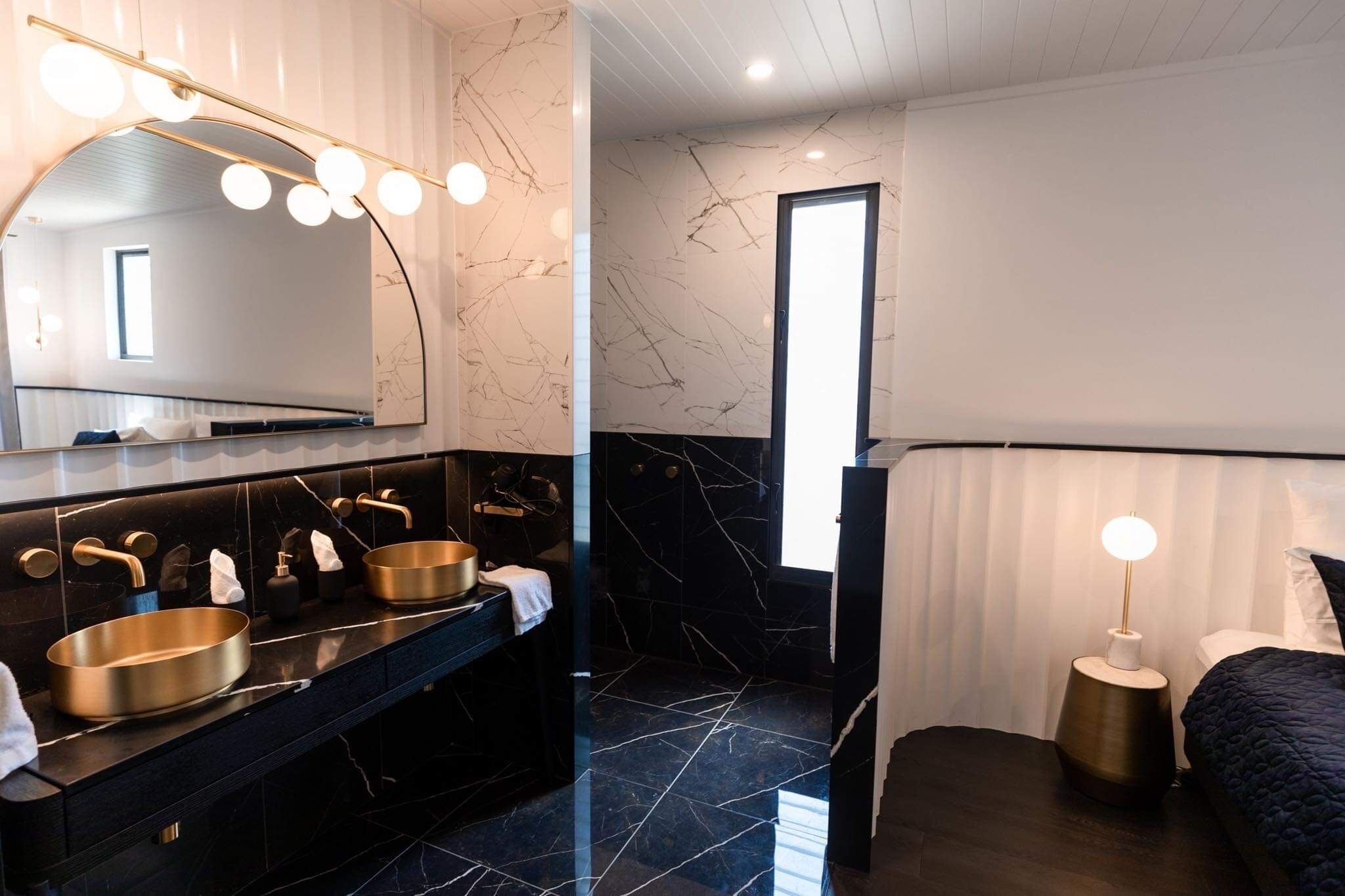A modern bathroom with a large mirror, dual sinks, and a vanity.