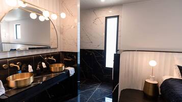 A modern bathroom with a large mirror, dual sinks, and a vanity.
