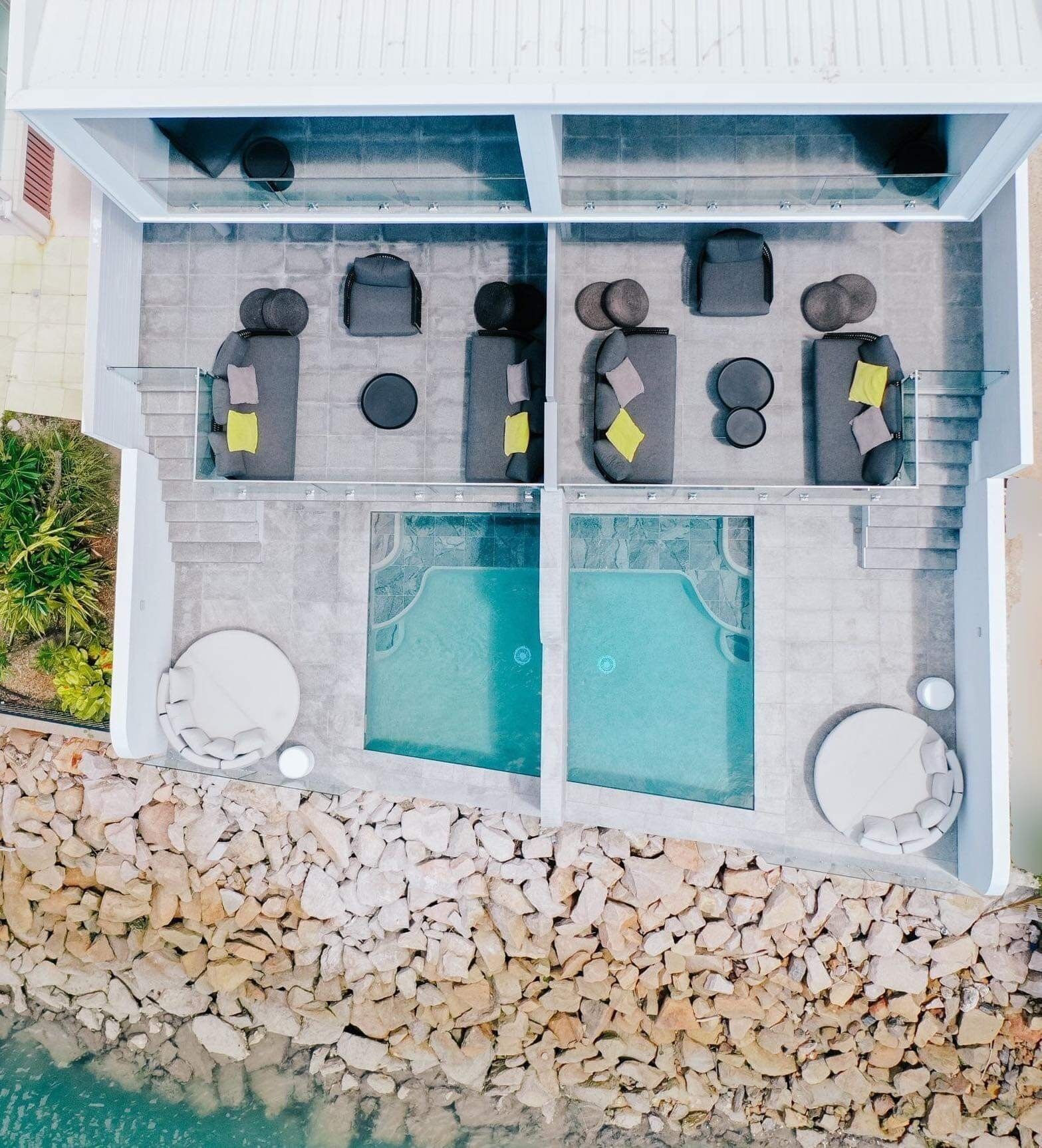 A spa area with a pool, seating, and a stone wall.