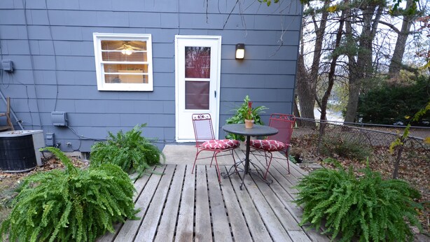 A wooden deck with a table and chairs, surrounded by potted plants. - State Line Rd near Downtown Q39 BBQ-KUMC. WESTPORT! (Kansas City)