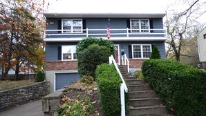 A two-story house with a brick base and a dark upper level. There is a front porch with a white railing, and a small tree in front of the house. - State Line Rd near Downtown Q39 BBQ-KUMC. WESTPORT! (Kansas City)