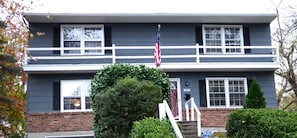 Stately two-story home with a charming front porch and well-manicured surroundings.