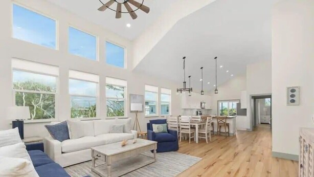A spacious living area with a sofa, coffee table, and dining table. - Beachwalk Luxury Home: Heated Pool & Free Bikes (Palm Coast)