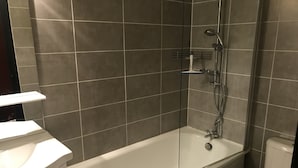 Uma casa de banho com banheira, sanita e lavatório.