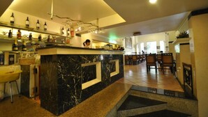 A bar area with a marble counter, wine bottles, and glasses. There are chairs and tables in the background. - S79 Vuon Saigon Hotel & Spa (Ho Chi Minh City)