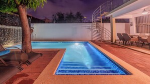 A swimming pool with a tiled edge, surrounded by a wooden deck and lounge chairs. - Elegant 4BR Home w/ Private Pool (Santiago De los caballeros)