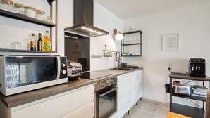 A modern kitchen with a microwave, toaster, oven, and a coffee maker on the counter. - Le Fonction, furnished 4*, boxed parking (Aix-en-Provence)