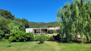 A modern house with a patio, surrounded by lush greenery and a clear blue sky. - Villa Olivia 10 minutes from Palombaggia without traffic jams (Porto-Vecchio)