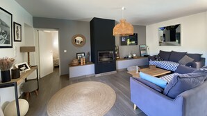 A modern living room with a sofa, a coffee table, a fireplace, and a television. - Villa Olivia 10 minutes from Palombaggia without traffic jams (Porto-Vecchio)