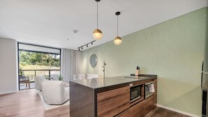 Une cuisine moderne dotée d’un îlot central, de meubles en bois et de luminaires suspendus.