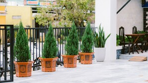 A balcony with potted plants and a table with chairs. - Hoi An Nguyen Homestay (Da Nang)