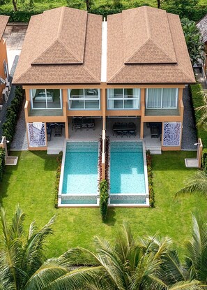 A two-story house with a swimming pool in the front, surrounded by a well-maintained lawn and palm trees. - Perla Pool Villa - Koh Chang (Ko Chang)