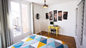 Un dormitorio con cama, escritorio y lámpara colgante.