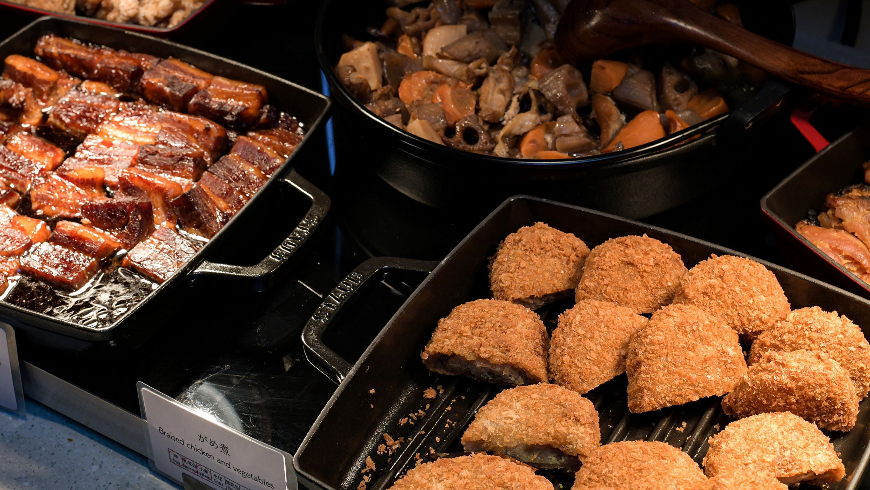 A buffet with various dishes including braised chicken, vegetables, and fried items.