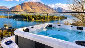 Un bain à remous offrant une vue dégagée sur un lac et des montagnes en arrière-plan.