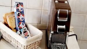 A coffee machine and a basket with bread and Nutella on a kitchen counter. - Penthouse with stunning views of St. Paul's Basilica (Roma)