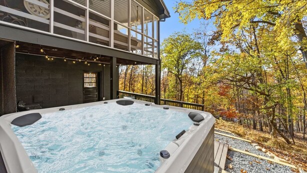 Ein Whirlpool vor einem Gebäude mit Blick auf Herbstbäume.