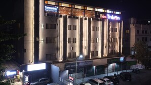 Un hôtel à étages, avec une enseigne « Tirgan » au sommet et une boutique « Shri Ganesh » au rez-de-chaussée.