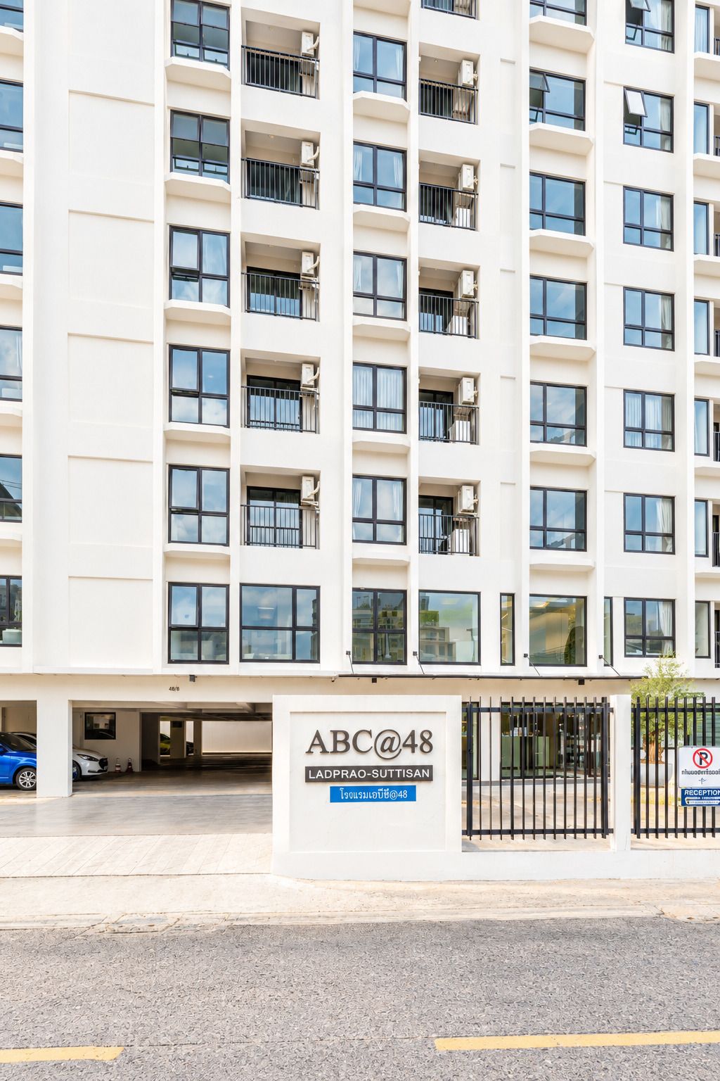 Um edifício de vários andares com uma placa indicando 'ABC@48' e 'LADPRAO-SUTTISAN'.