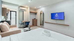 A modern hotel room with a bed, a TV, a dining area, and a bathroom. - ABC@48 Hotel & Service Apartment (Bangkok)