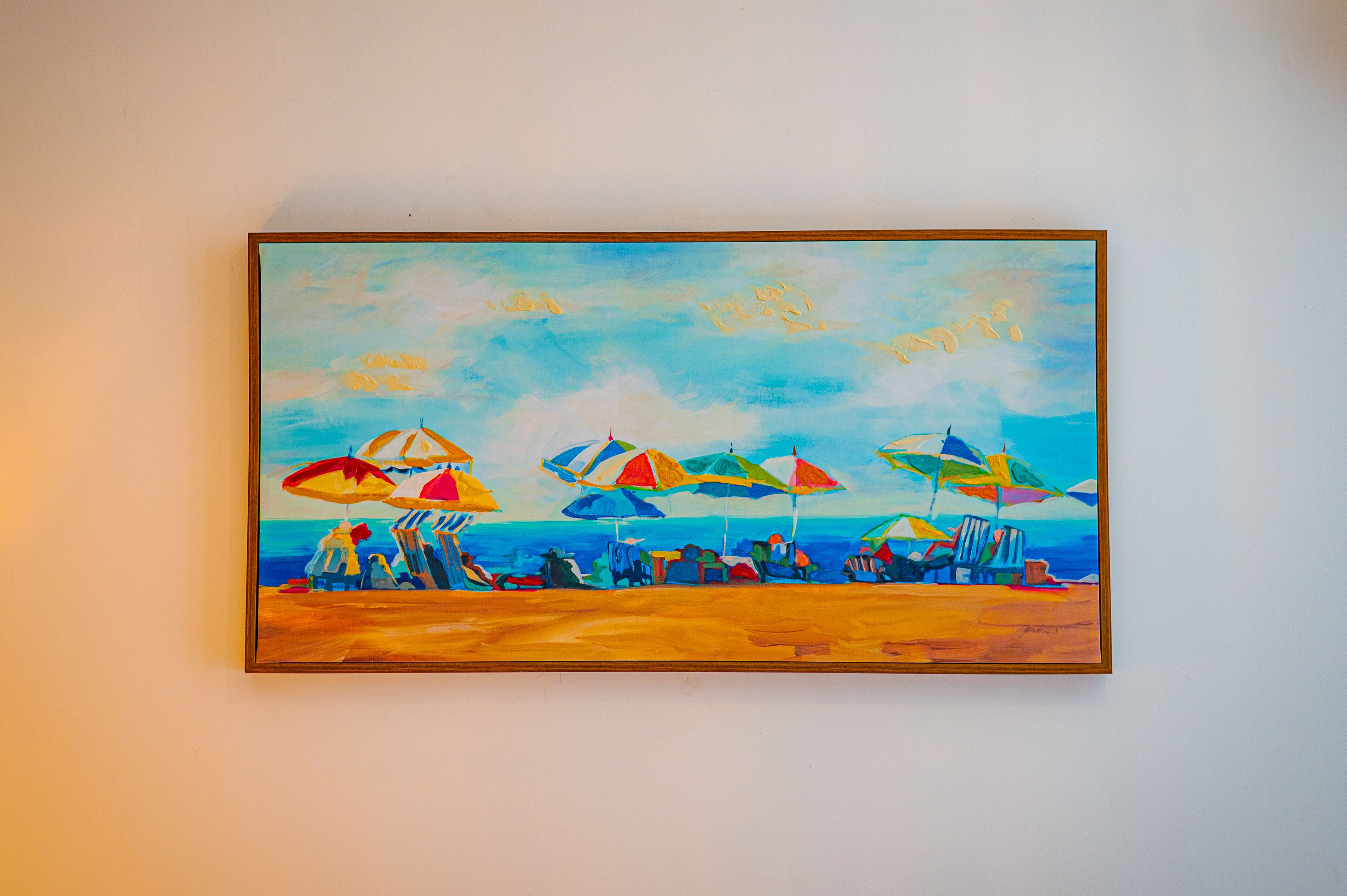 A painting of a beach scene with umbrellas and people.