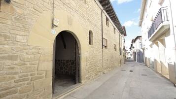 Una calle estrecha con edificios de piedra, uno con el número '58' visible y una entrada en arco.