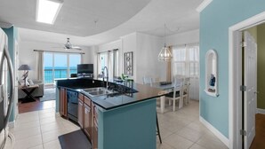 Una cocina amplia con una isla grande, comedor y vista al océano.