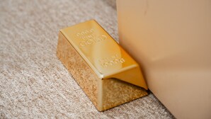 Goudstaaf met '999.9 Zuiver Goud' en 'Netto gewicht 1000g' op een gestructureerd oppervlak.