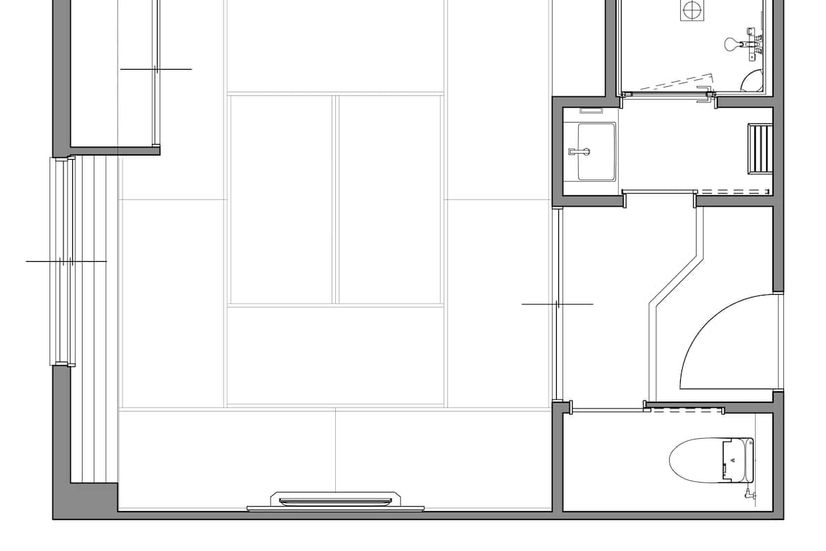 A floor plan with a large central open space, a kitchen area, a bathroom, and a small seating area.