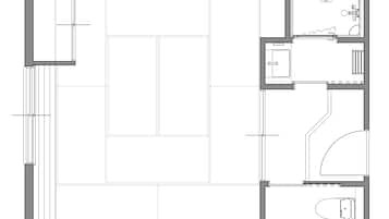 Un plan d’étage comprenant un grand espace central ouvert, une cuisine, une salle de bain et un petit coin salon.
