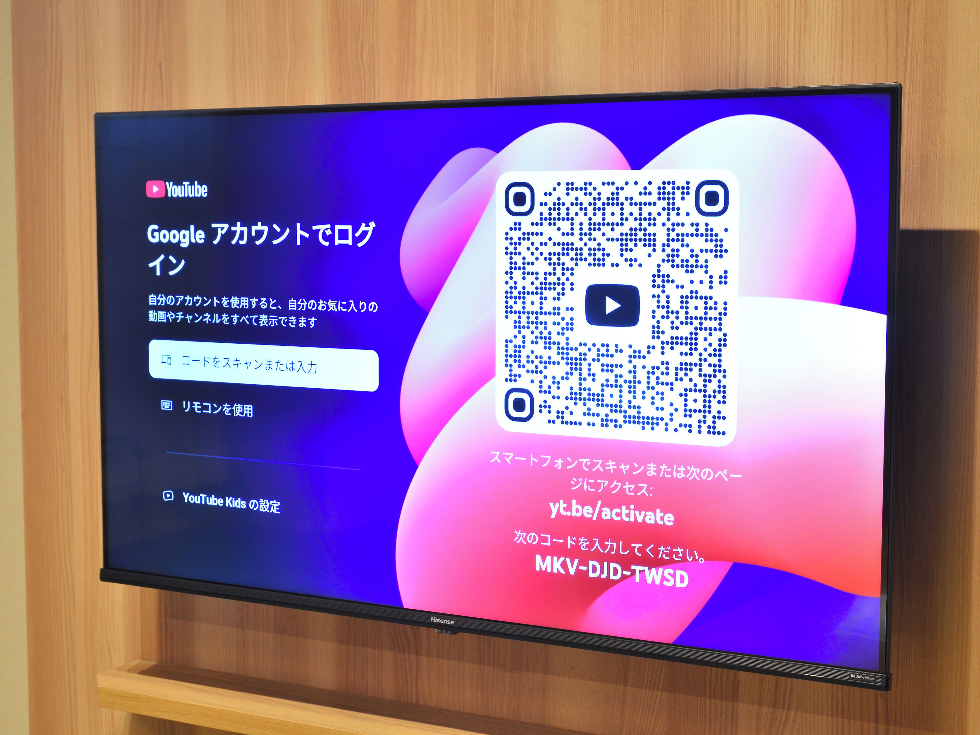A flat-screen TV displaying a QR code and YouTube logo.