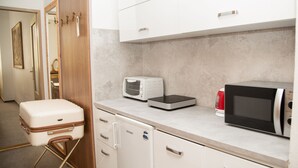 Eine kleine Küchenzeile mit Mikrowelle, Toaster und kleinem Kühlschrank.