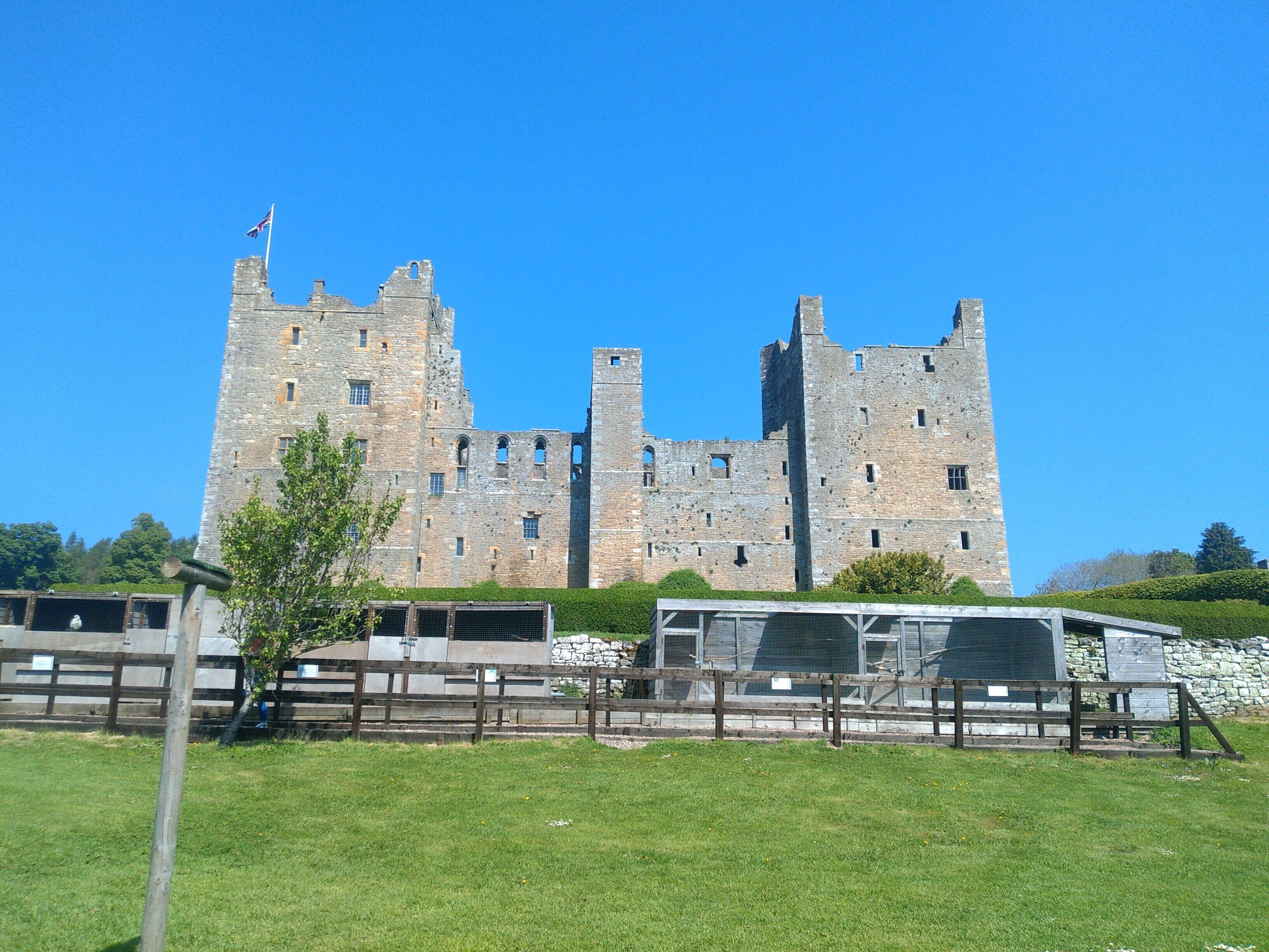 A historic stone castle with multiple towers and a flag on top.