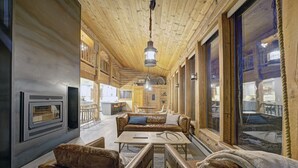 Un interior acogedor con chimenea, muebles de cuero y ventanas amplias.