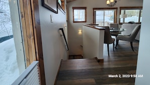 A modern interior with a wooden staircase, a dining area with a table and chairs, and large windows offering a view of the outside. - Newly remodeled Old town/2 King Suites
Pet Friendly
Deck/Grill
EV/Carport (Steamboat Springs)