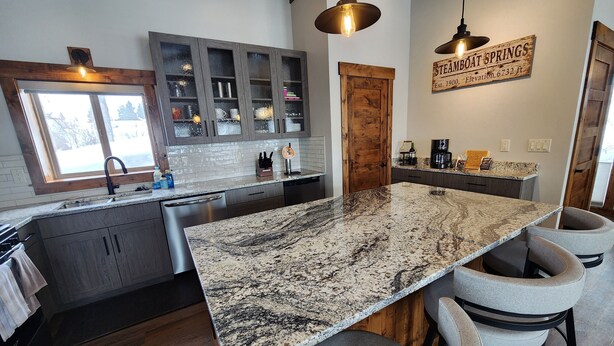A kitchen with a large island, dark wood cabinets, and a sign reading "STEAMBOAT SPRINGS." - Newly remodeled Old town/2 King Suites
Pet Friendly
Deck/Grill
EV/Carport (Steamboat Springs)