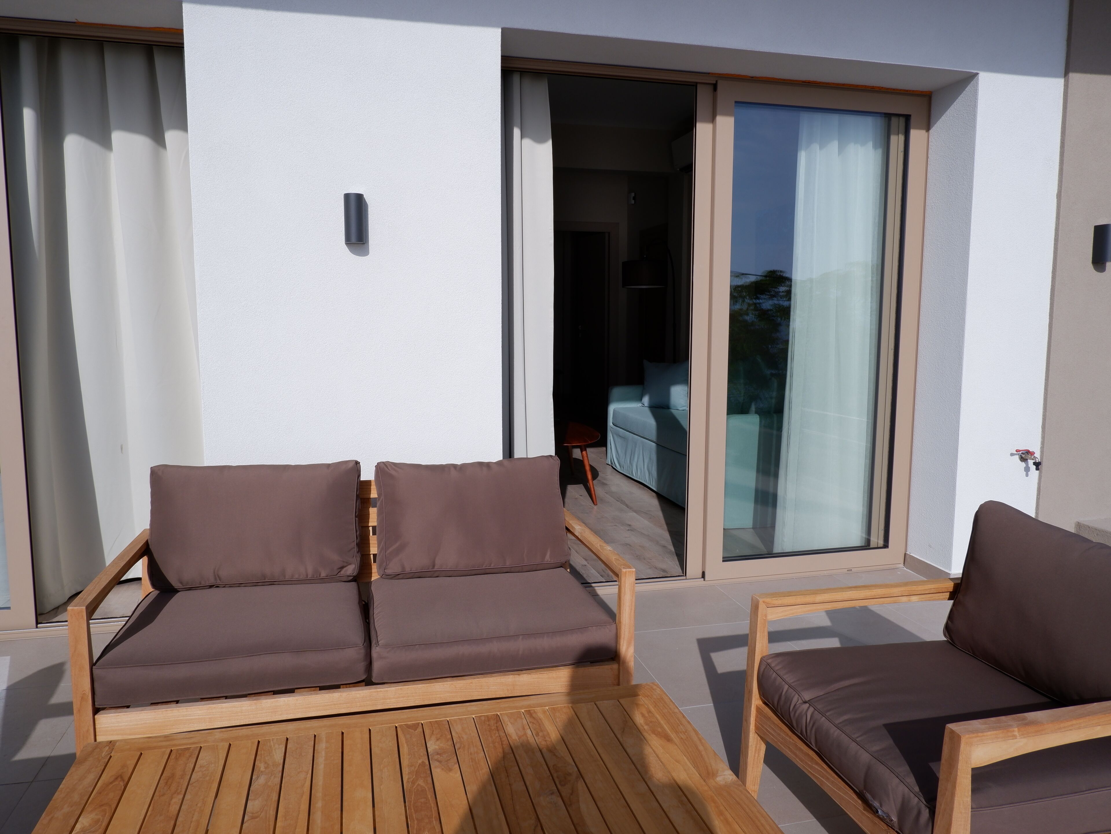 Ein moderner Außenbereich mit einem Holztisch und zwei Sofas.