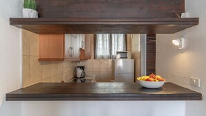Une cuisine moderne avec des meubles en bois, un four à micro-ondes et un saladier rempli de fruits sur le plan de travail.