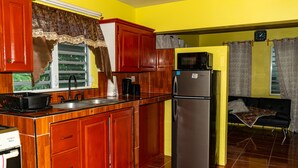A kitchen with wooden cabinets, a stainless steel refrigerator, and a microwave.