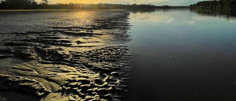 A calm river at sunset with a clear sky.