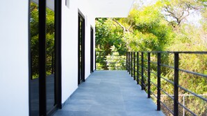 A corridor with a tiled floor, black railings, and large windows on one side. - Luxurious Villa with expansive room for family, couples/groups. 5 min beach walk (San Luis La Herradura)