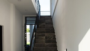 A staircase with dark stone steps and a black railing, leading to an upper floor. - Luxurious Villa with expansive room for family, couples/groups. 5 min beach walk (San Luis La Herradura)